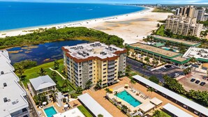 A high-rise hotel with multiple balconies, a swimming pool, and a beach view. - Sand Caper by Distinctive Beach Rentals (Fort Myers Beach)