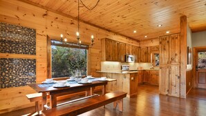 A wooden interior with a dining area, kitchen, and large windows. - Toccoa Sunnyside ~ Minutes to Downtown Blue Ridge ~ Hot Tub! (Blue Ridge)