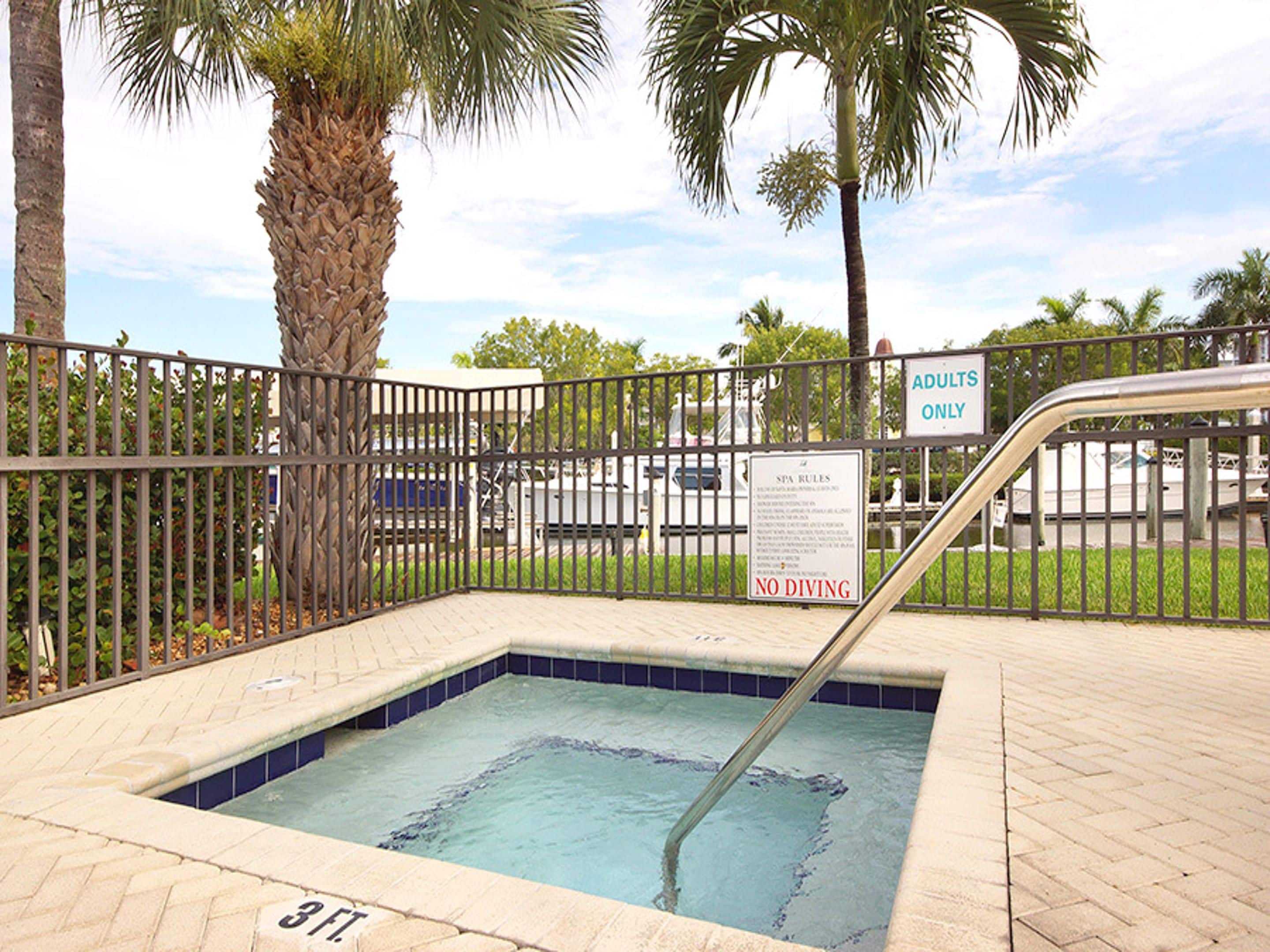 A small pool area with a sign indicating 'ADULTS ONLY' and 'NO DIVING'.
