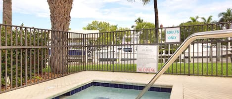 A small pool area with a sign indicating 'ADULTS ONLY' and 'NO DIVING'.