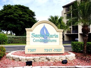A sign for Santa Maria Condominiums with a contact number. - Santa Maria by Distinctive Beach Rentals (Fort Myers Beach)