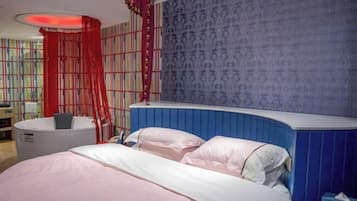 Un dormitorio con cama, mesita de noche, cortina roja y pared con diseño azulado.