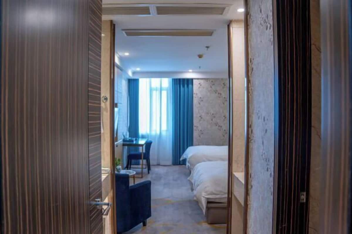 A hotel room with a bed, a desk, and a chair.