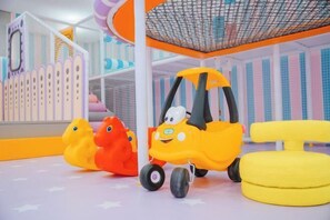 A play area with a yellow car, two rubber ducks, and a yellow chair. - Yinhehui Hotel (Changchun Railway Station Sasseur Zhongdong Outlet) (Changchun)