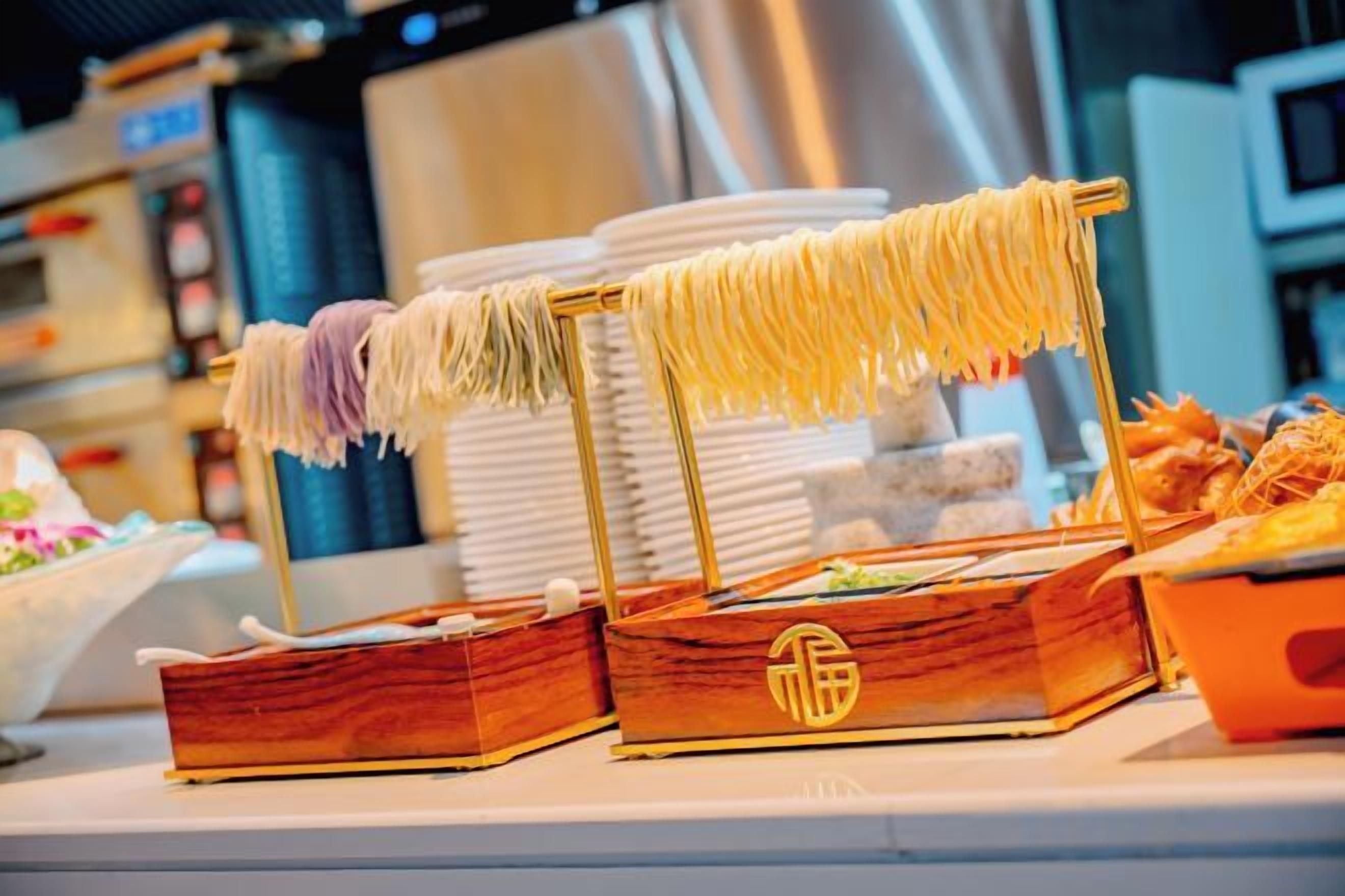 Una mesa de buffet con pasta y pan a la vista.