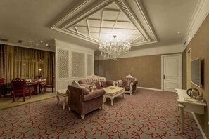 A spacious room with a large chandelier, a sofa set, a dining area, and a large window with a view. - Yinhehui Hotel (Changchun Railway Station Sasseur Zhongdong Outlet) (Changchun)
