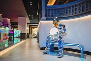 A modern interior with a curved railing, a bench, and a glass display case. - Yinhehui Hotel (Changchun Railway Station Sasseur Zhongdong Outlet) (Changchun)