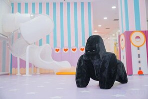 A plush toy gorilla in a brightly colored indoor play area with a slide and heart-shaped decorations. - Yinhehui Hotel (Changchun Railway Station Sasseur Zhongdong Outlet) (Changchun)