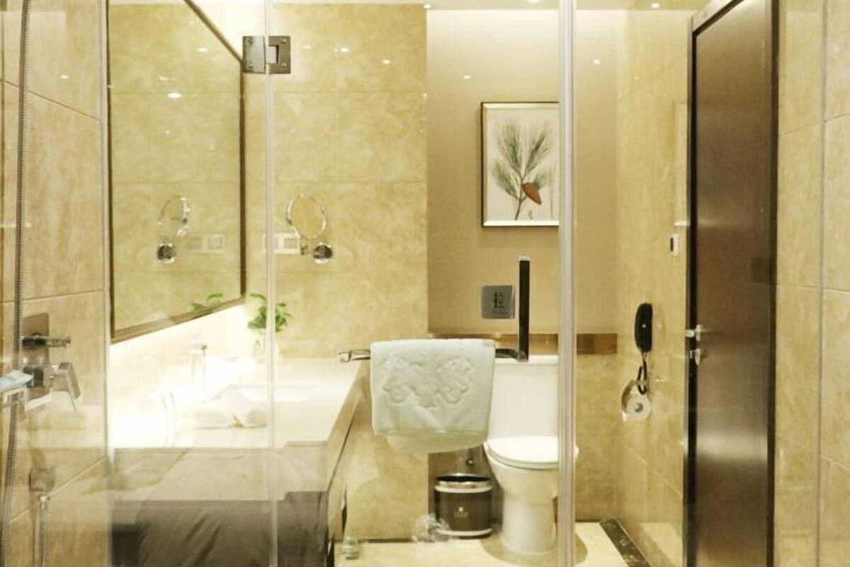 Un baño moderno con ducha de vidrio, bañera y retrete.