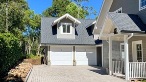 A modern two-story house with a garage, a covered porch, and a brick driveway. - Cozy apartment for your family. (RS)