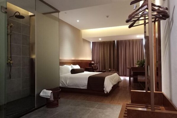 A modern hotel room with a large bed, a shower area, and a wooden chair. - Wuyue Yuexin Hotel (Meidi Impression Wuyue Plaza Branch) (Shangrao)