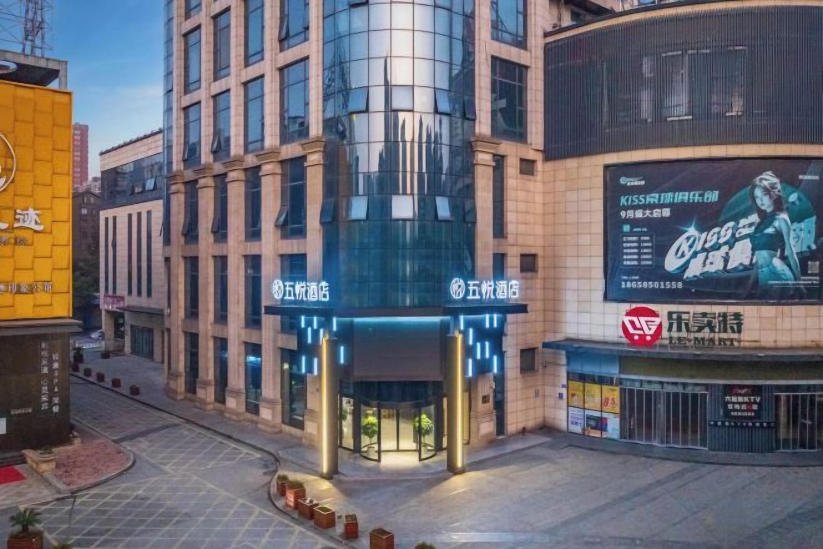 Un hotel amb façana moderna, una senyalització gran i un cartell digital destacat.