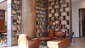 A modern library with leather seating and wooden bookshelves.