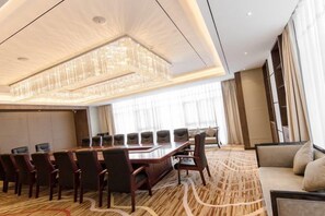 A conference room with a long table, chairs, and a chandelier.