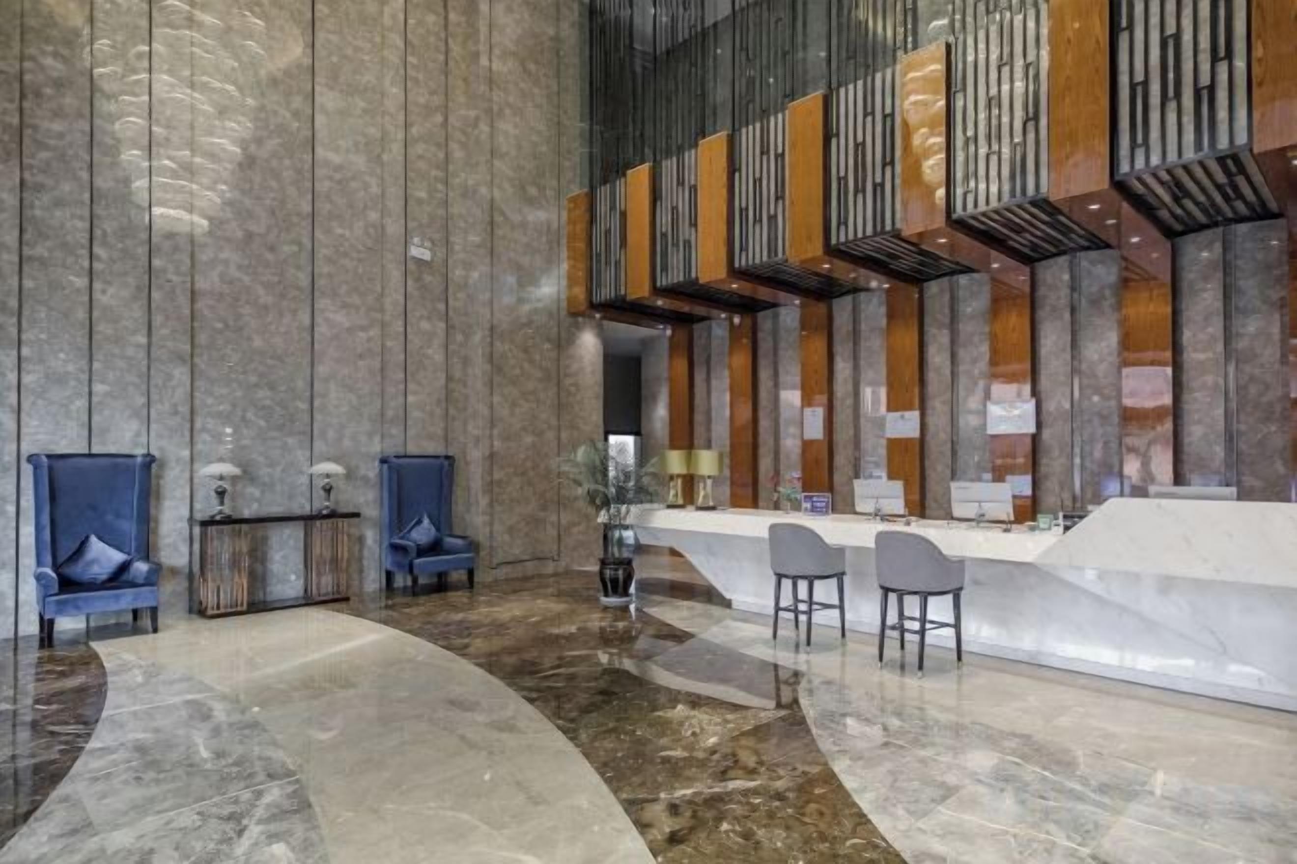 A lobby with a reception desk, seating area, and a large wall with vertical lines.