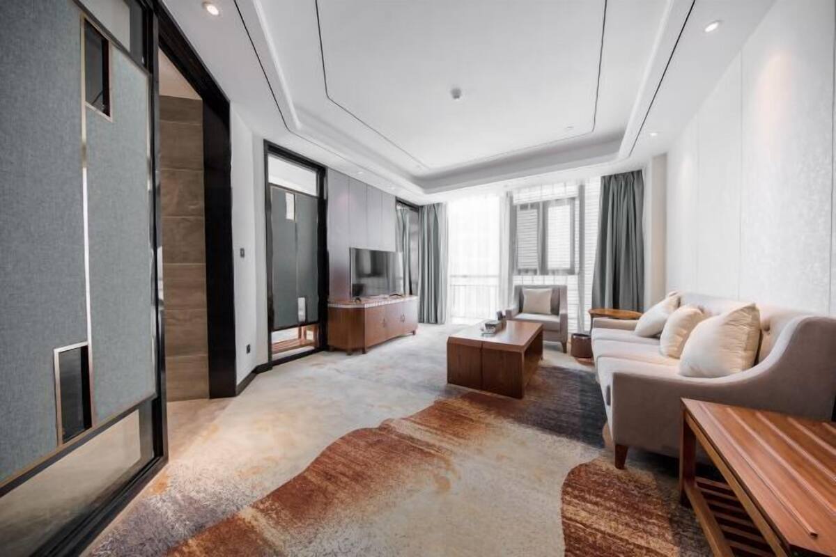 A modern living room with a sofa, coffee table, and a TV.