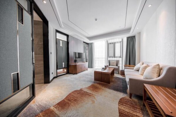 A modern living room with a sofa, coffee table, and a TV.