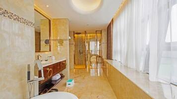 A modern bathroom with a large mirror, a bathtub, a vanity with a sink, and a shower area.