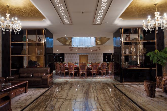 A spacious room with a dining area, a seating area with a sofa, and a chandelier.