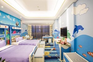 Una habitación infantil con dos camas, un escritorio y un televisor.