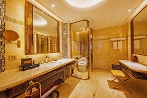 Un baño moderno con un espejo grande, dos lavamanos, un inodoro y una zona de ducha.