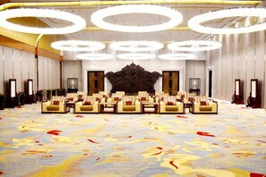 A large room with a patterned carpet, multiple rows of chairs, and a central decorative piece. - Oriental Grand Hotel Shaoxing (Shaoxing)