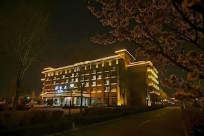 A multi-story hotel with illuminated windows and a well-lit facade at night. - Shenghao Seasons Hotel (Huimin)