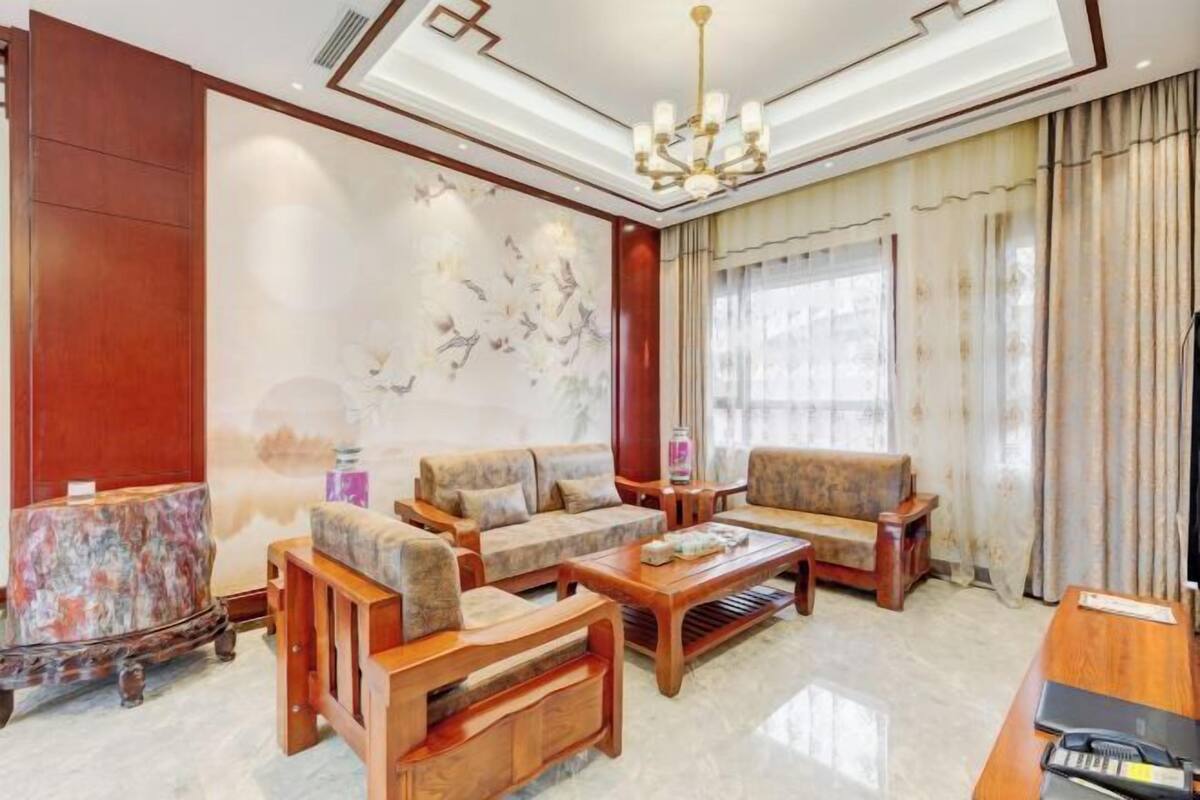 A spacious living room with a sofa set, coffee table, and a wooden side table.
