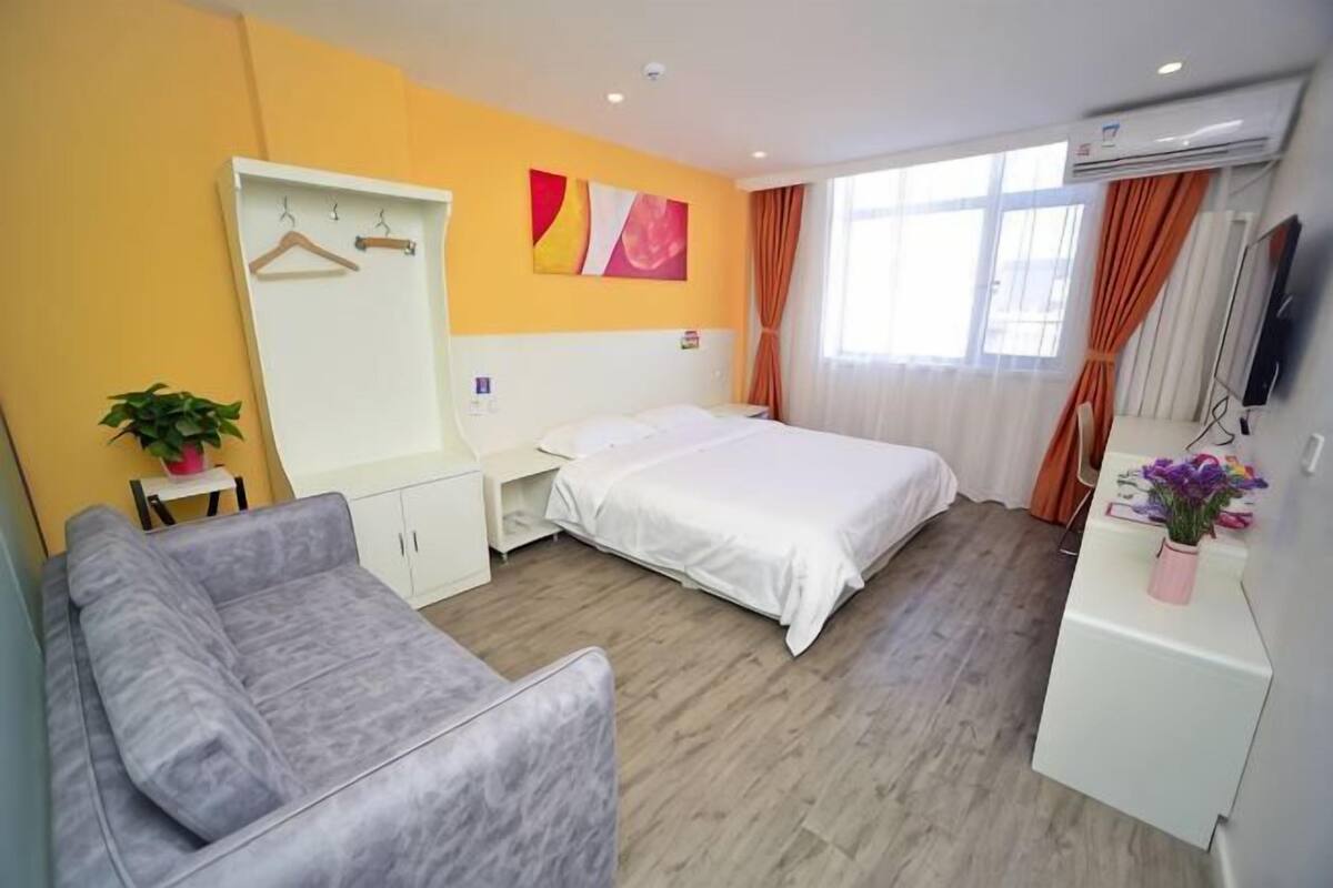 Une chambre d’hôtel comprenant un lit, un bureau, une chaise, une armoire et un téléviseur.
