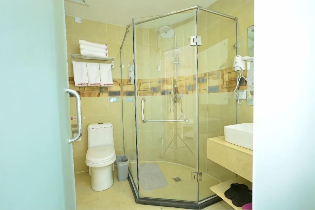 A glass-enclosed shower stall with a toilet and sink.