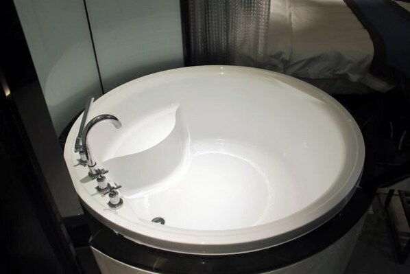 A white oval-shaped sink with a single faucet in a modern bathroom. - Yunman Life Hotel (Xuyong)