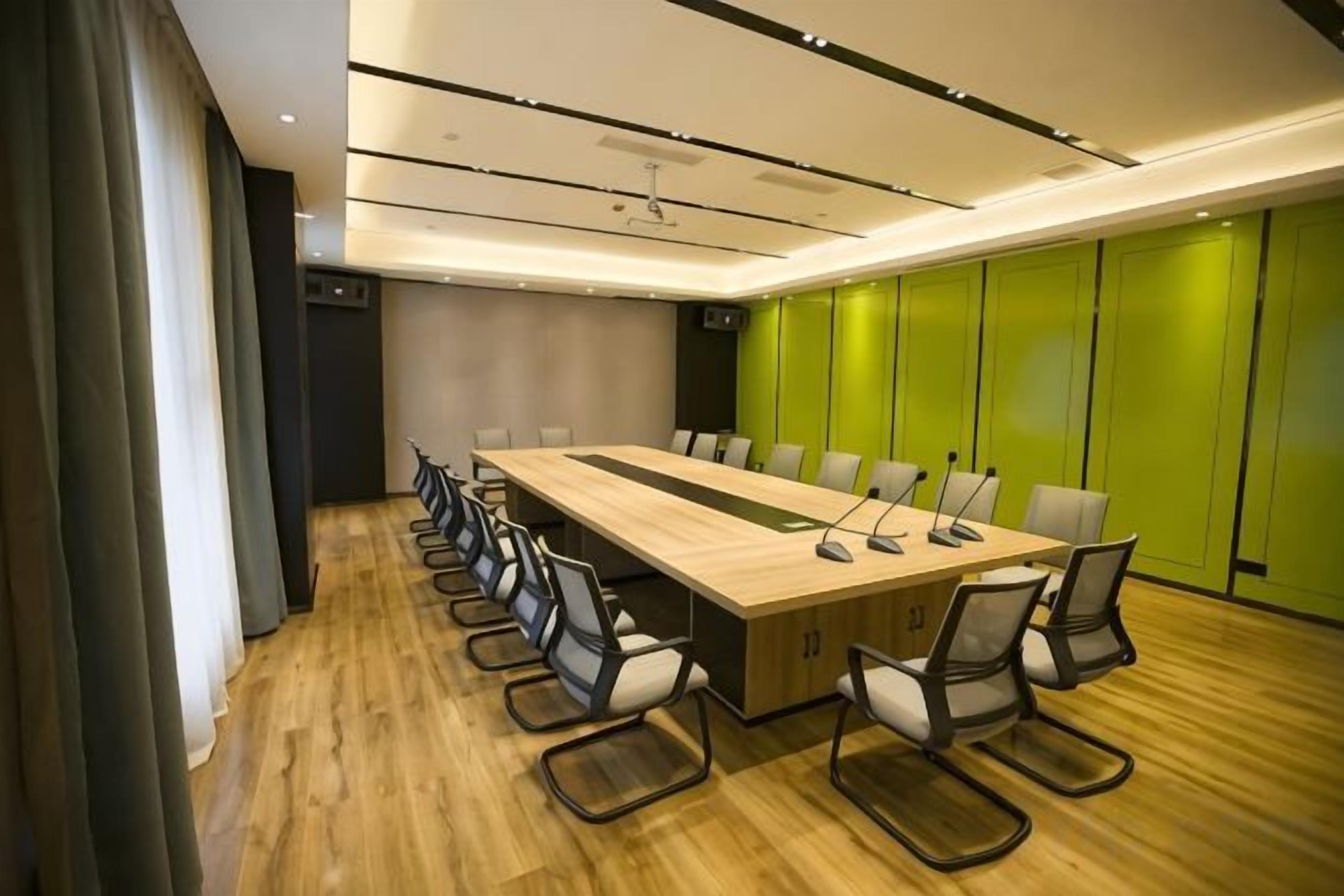 A conference room with a long table, chairs, and a microphone.