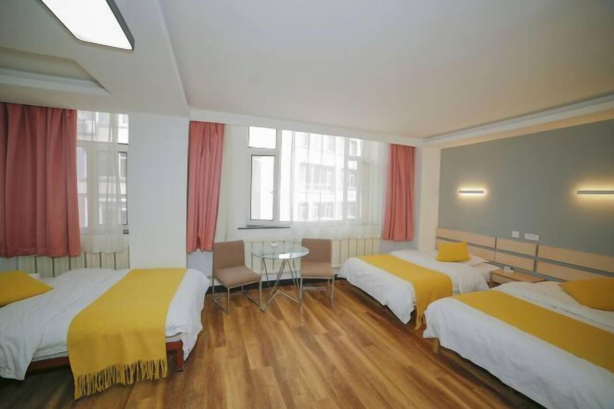 A hotel room with two beds, a small table, and chairs.