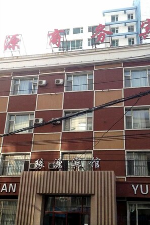 A multi-story building with a sign indicating a hotel. There are multiple windows on each floor, and the building has a modern architectural style. - Changchun Yuanyuan Business Hotel (Jida Second Hospital Yatai Hospital Area Branch) (Changchun)