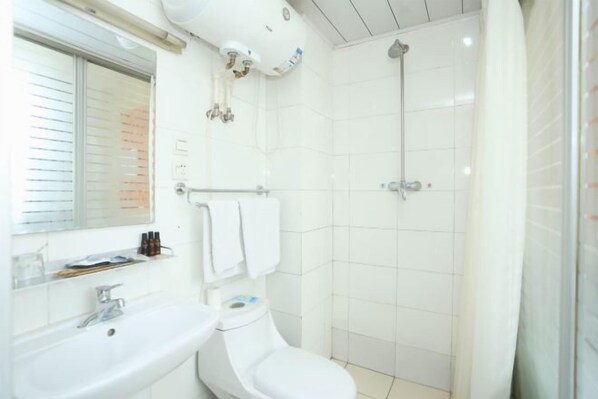 A bathroom with a white sink, toilet, and shower. - Changchun Yuanyuan Business Hotel (Jida Second Hospital Yatai Hospital Area Branch) (Changchun)
