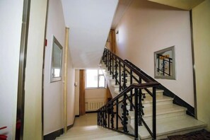 A staircase with a wooden handrail and a radiator on the wall. - Changchun Yuanyuan Business Hotel (Jida Second Hospital Yatai Hospital Area Branch) (Changchun)