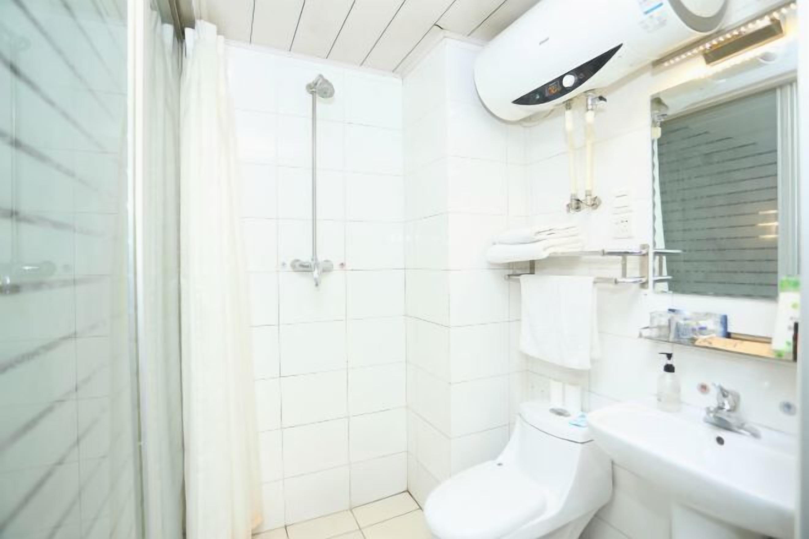 A modern bathroom with a glass shower enclosure, a white toilet, and a sink with a mirror.