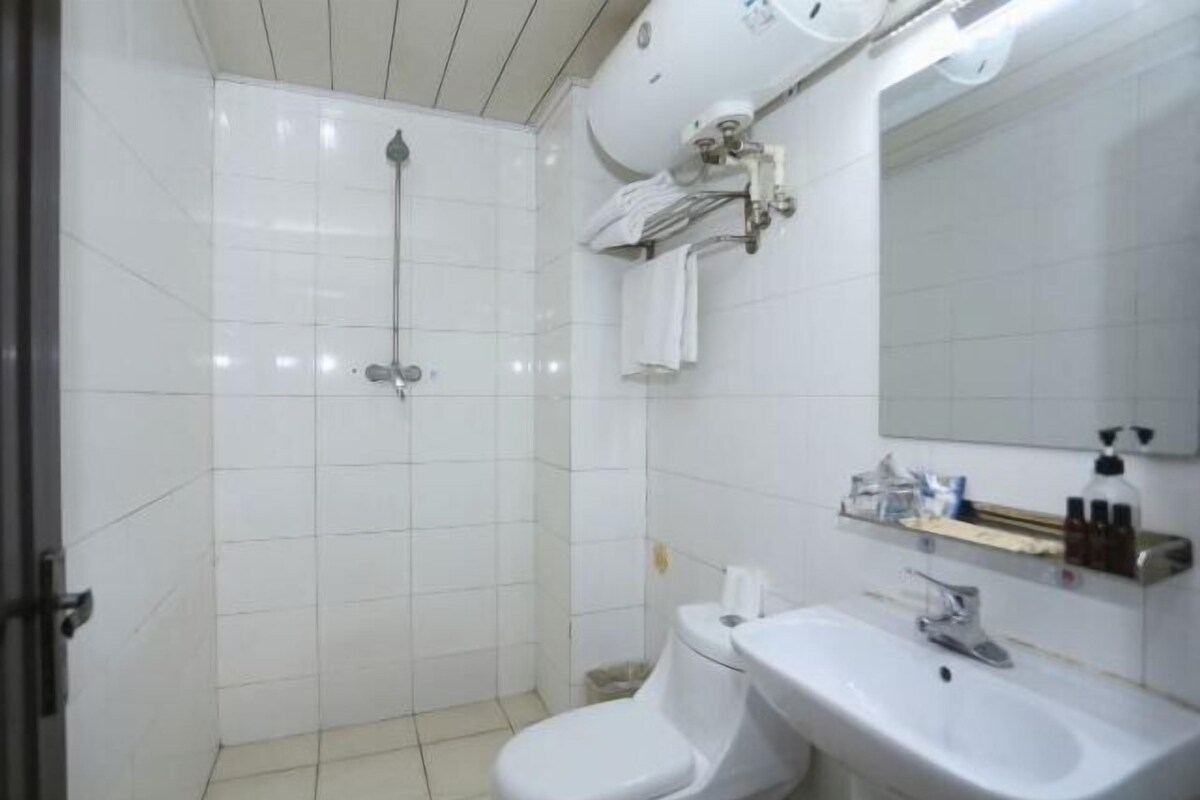 A bathroom with a toilet, sink, and shower.