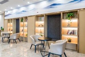 Una biblioteca moderna con estanterías, asientos y objetos decorativos.