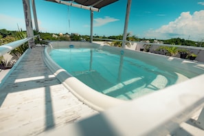 A rooftop swimming pool with a clear view of the surrounding landscape.