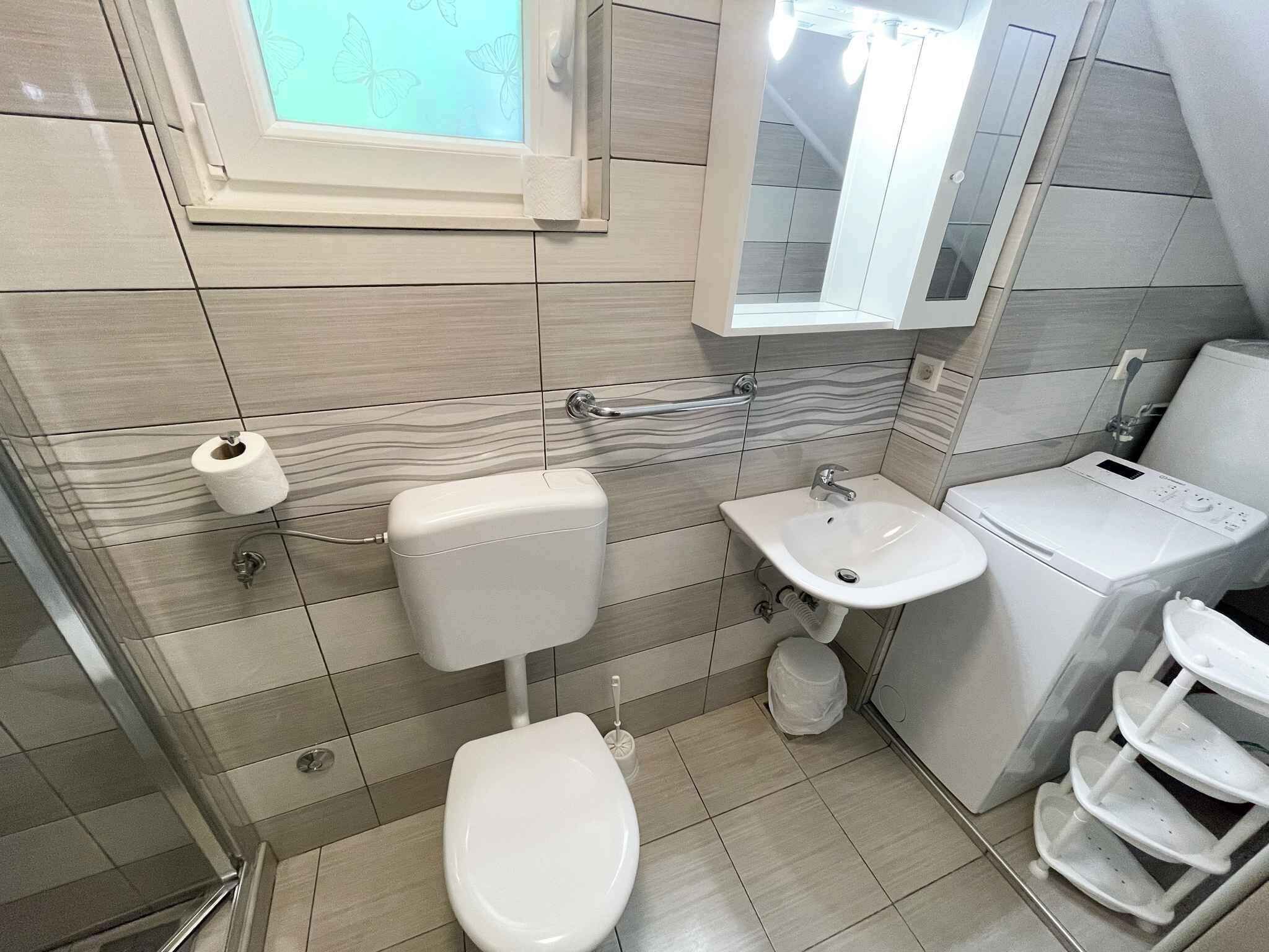 Un baño moderno con inodoro, lavamanos y lavadora.