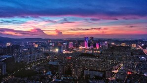 A cityscape at dusk with illuminated buildings and a colorful sky. - Jiangmen Park Lane Yiju Hotel (Wuyi University Jianshe Road) (Jiangmen)