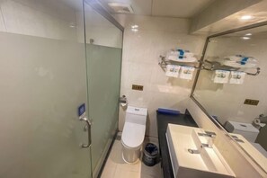 A compact bathroom with a glass partition, a toilet, a sink, and a mirror. - Jiangmen Park Lane Yiju Hotel (Wuyi University Jianshe Road) (Jiangmen)