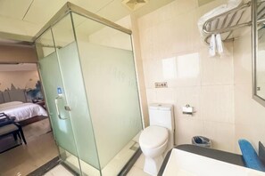 A hotel bathroom with a glass shower enclosure, a toilet, and a sink. - Jiangmen Park Lane Yiju Hotel (Wuyi University Jianshe Road) (Jiangmen)