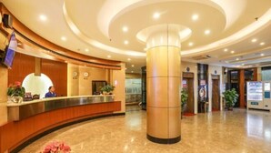 A hotel lobby with a reception desk, a large central pillar, and a vending machine. - Jiangmen Park Lane Yiju Hotel (Wuyi University Jianshe Road) (Jiangmen)