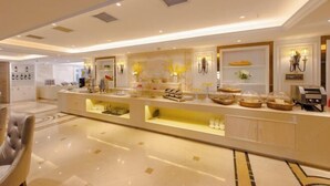 Een moderne hotelentree met een centraal receptiegedeelte, een zithoek en decoratieve details.