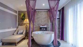 A modern bathroom with a freestanding bathtub, a massage chair, and a stone wall backdrop.