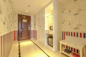 A hallway with a wooden door, a white bench, and a patterned wall.