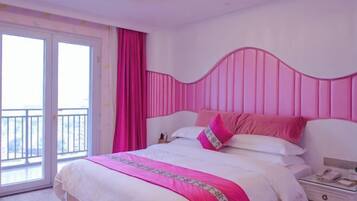 Habitación de hotel con una cama, mesita de noche, teléfono y vistas al exterior.