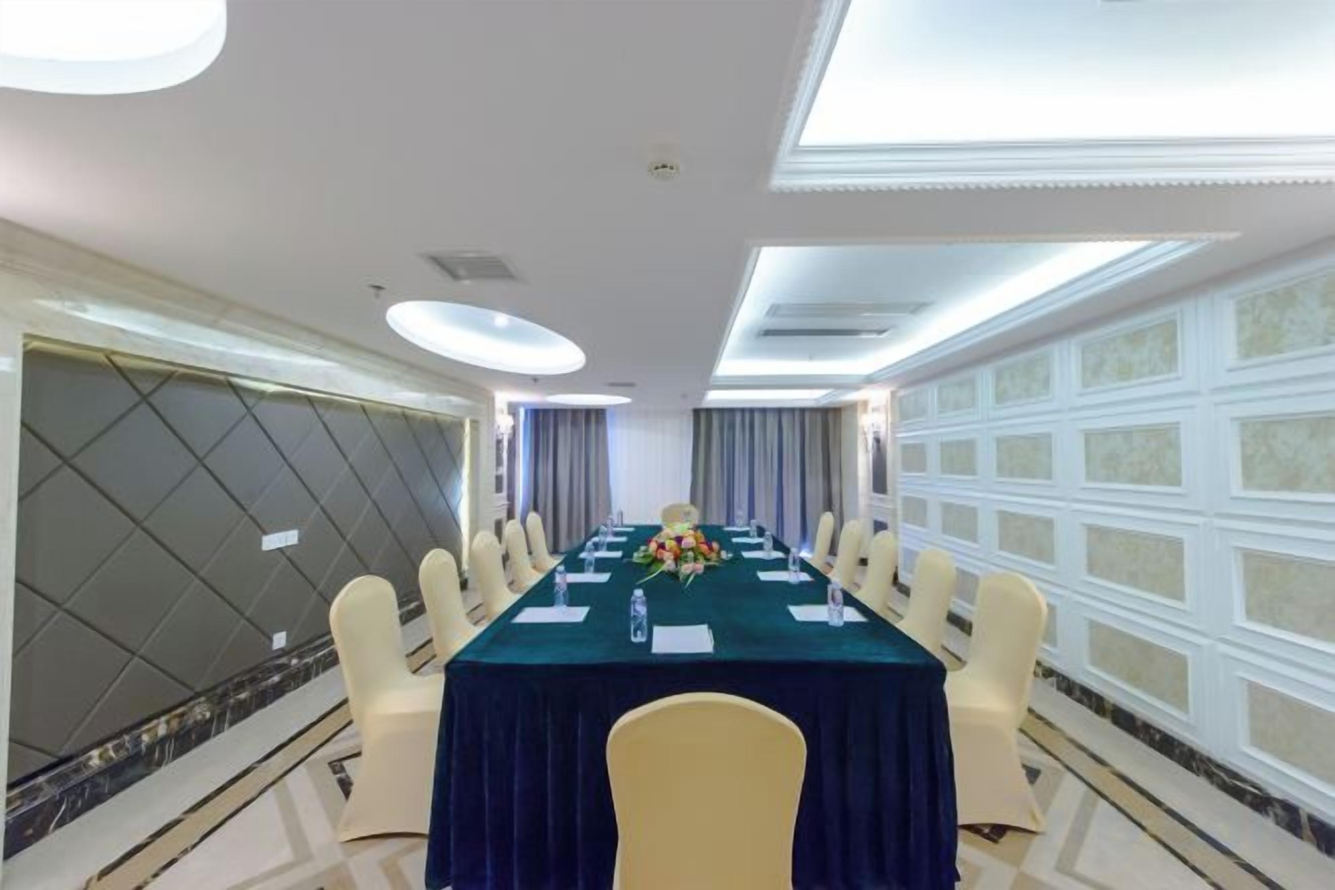 A conference room with a long table, chairs, and a floral centerpiece.